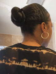 African-American woman with natural wavy hair in a bun.